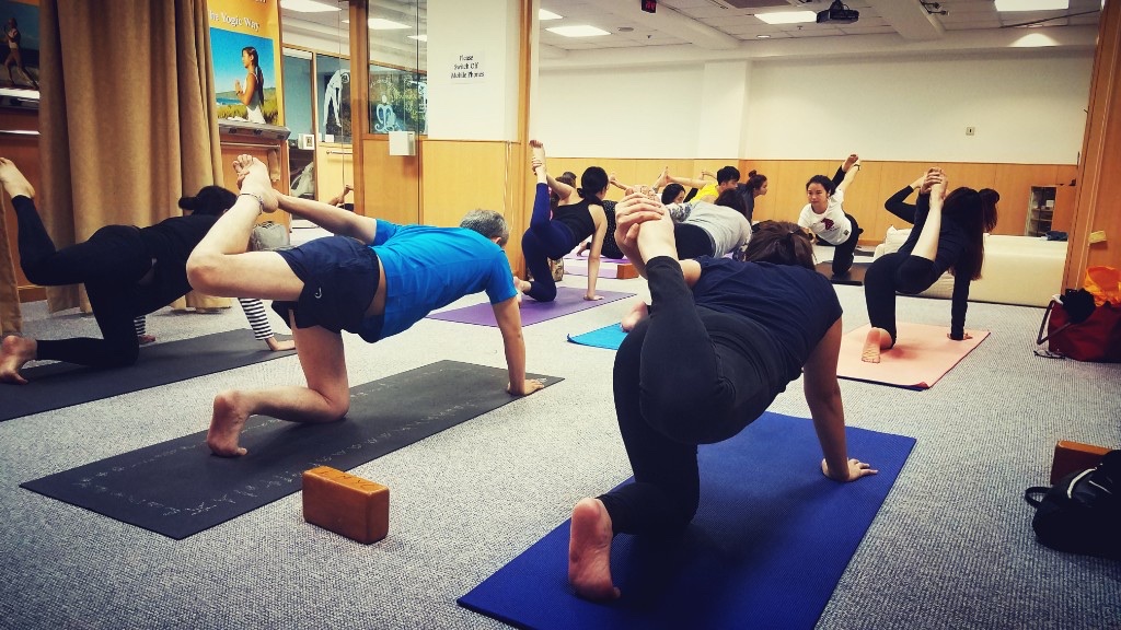 Group practising balancing poses on mats in the LMYC studio